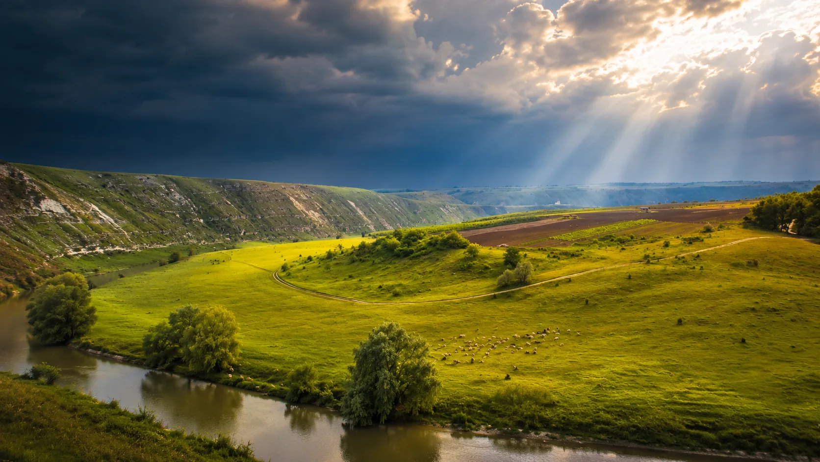 Răut river and limestone cliffs at Orheiul Vechi under dramatic sun rays